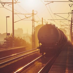 Freight train leaving from railroad station at sunrise.